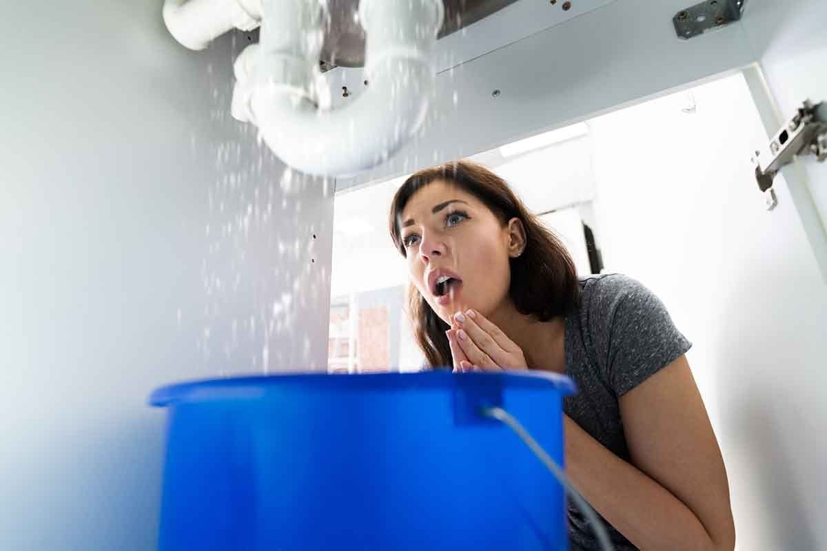 woman fixing sink leak